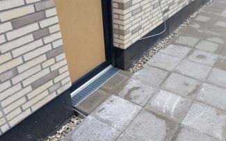 The facade and terrace drainage channels in the paved area around the door ensure that the stormwater flows off quickly into the underlying drainage layer. © GRÜN+DACH / ZinCo Facade and terrace drainage channels